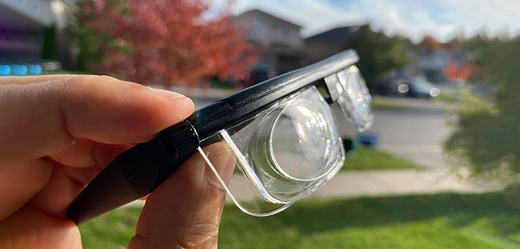 SmartFocus glasses man holding the glasses in his backyard